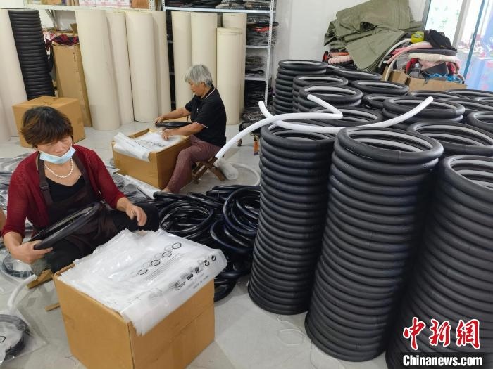 圖為村民在汽車飾品企業(yè)生產(chǎn)車間中工作?！巫雍?攝