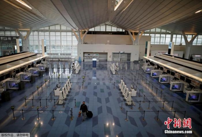 資料圖：日本東京，東京國際機(jī)場，一名乘客在國際航班航站樓的登機(jī)區(qū)。