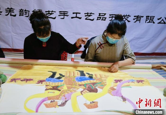 圖為皮繡藝人在市集上“秀”指尖技藝?！●R銘言 攝