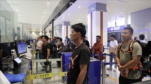 6月13日，乘坐中老鐵路國際旅客列車的旅客在磨憨邊檢大廳排隊候檢。李揚 攝