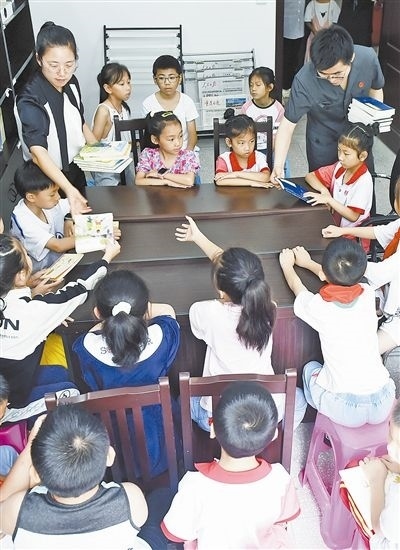  圖④：法院干警為留守兒童發(fā)放暑假讀物。