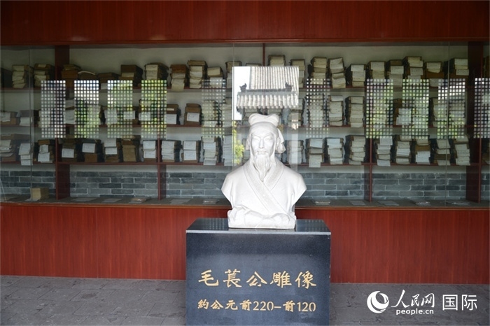 河間詩(shī)經(jīng)齋毛萇雕像。雕像后書櫥中陳列的是歷代各版本《詩(shī)經(jīng)》及譯本。 人民網(wǎng) 趙昭攝