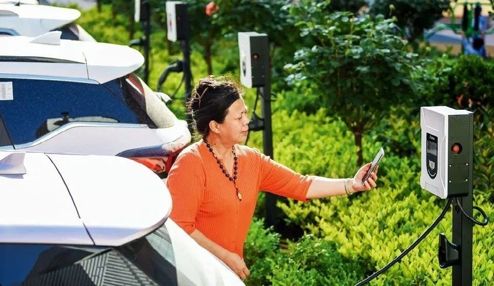 2023年5月24日，山東省膠州市新立街小區(qū)內(nèi)一位居民使用電動汽車充電樁掃碼充電。該小區(qū)加裝各類智慧設(shè)備，打造“智慧社區(qū)”，為居民生活帶來便利。