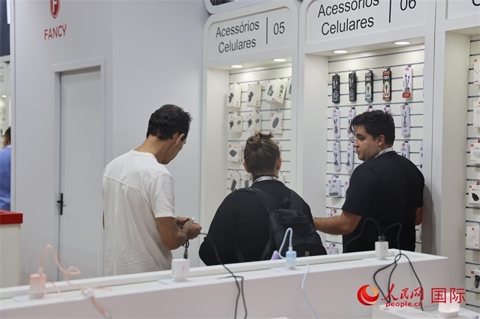 幾名參觀者在一個(gè)展臺(tái)前了解手機(jī)配件。（人民網(wǎng)記者 時(shí)元皓攝）