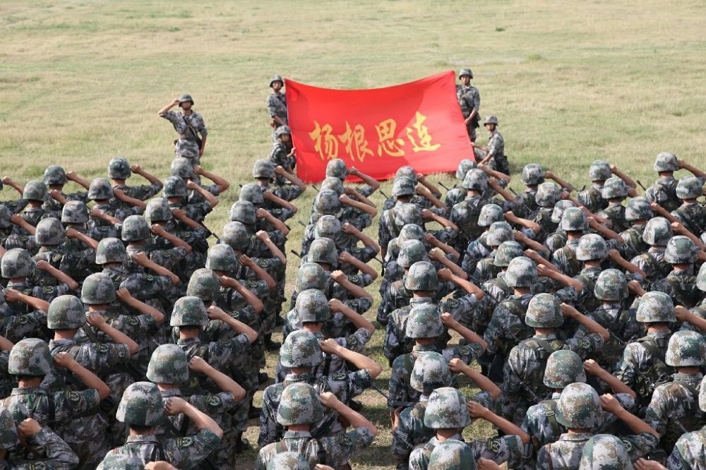 ↑“楊根思連”官兵執(zhí)行任務(wù)前向連旗宣誓（資料照片）。新華社發(fā)