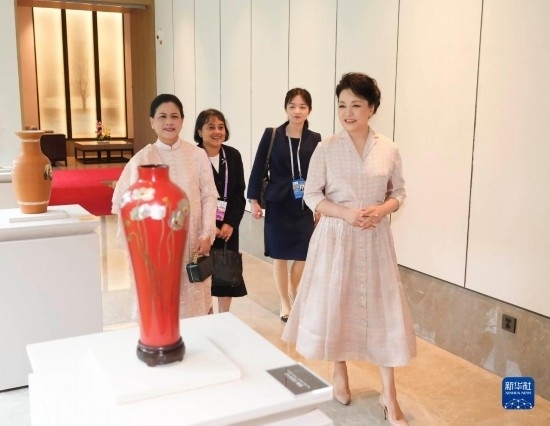 7月27日下午，國家主席習近平夫人彭麗媛在四川成都會見陪同印度尼西亞總統(tǒng)佐科來華出席第31屆世界大學生夏季運動會開幕式并訪華的總統(tǒng)夫人伊莉亞娜。這是彭麗媛和伊莉亞娜欣賞成都特色非遺工藝品。新華社記者 丁林 攝
