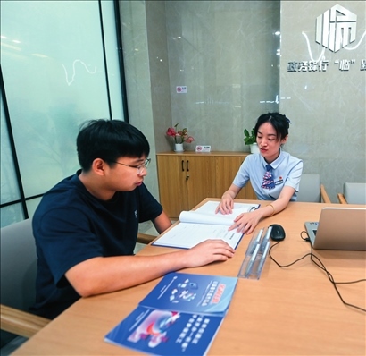 在杭州市臨安區(qū)政務(wù)服務(wù)中心的“為企服務(wù)中心”，黨員志愿者（右）解答企業(yè)主的疑問(wèn)（2023年7月7日攝）。徐昱攝/本刊