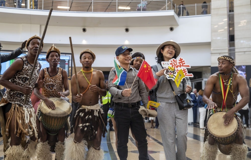 在南非約翰內(nèi)斯堡坦博國際機(jī)場，南非舞蹈演員歡迎中國試點(diǎn)恢復(fù)出境團(tuán)隊(duì)旅游后首批抵達(dá)南非的中國游客（2023年3月29日攝）。