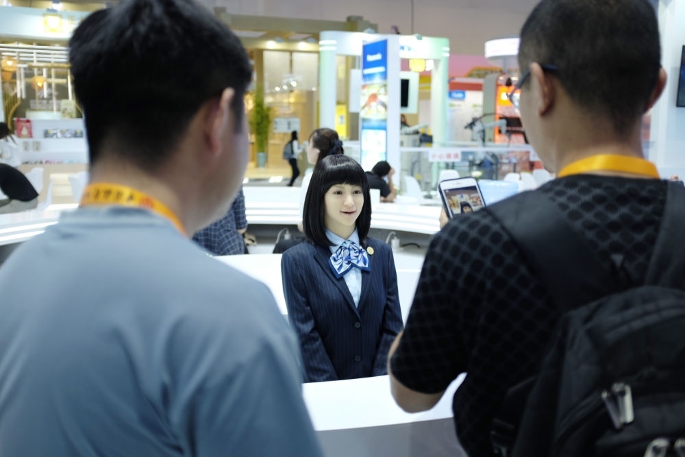 9月1日，媒體記者在國家會議中心與服務(wù)機(jī)器人互動。新華社記者 劉夢琪 攝