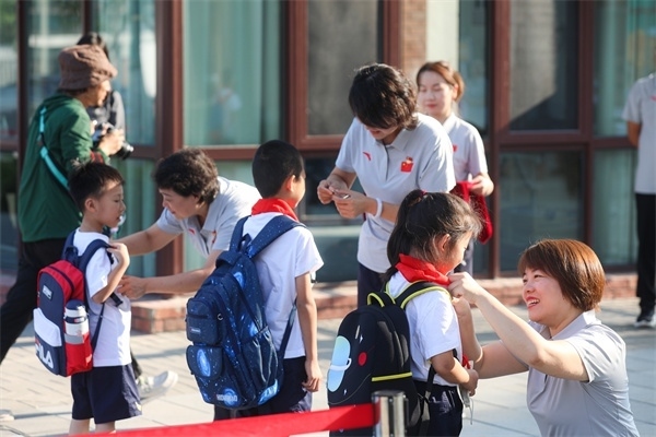 8月30日，雄安史家胡同小學(xué)學(xué)生體驗學(xué)校生活。老師為學(xué)生佩戴?；铡? /></p> <p style=