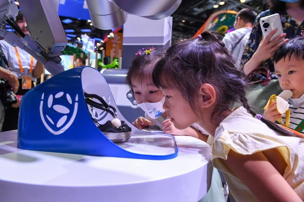 9月3日，幾名小朋友在國(guó)家會(huì)議中心觀看單孔腔鏡手術(shù)機(jī)器人展示。新華社記者 鞠煥宗 攝