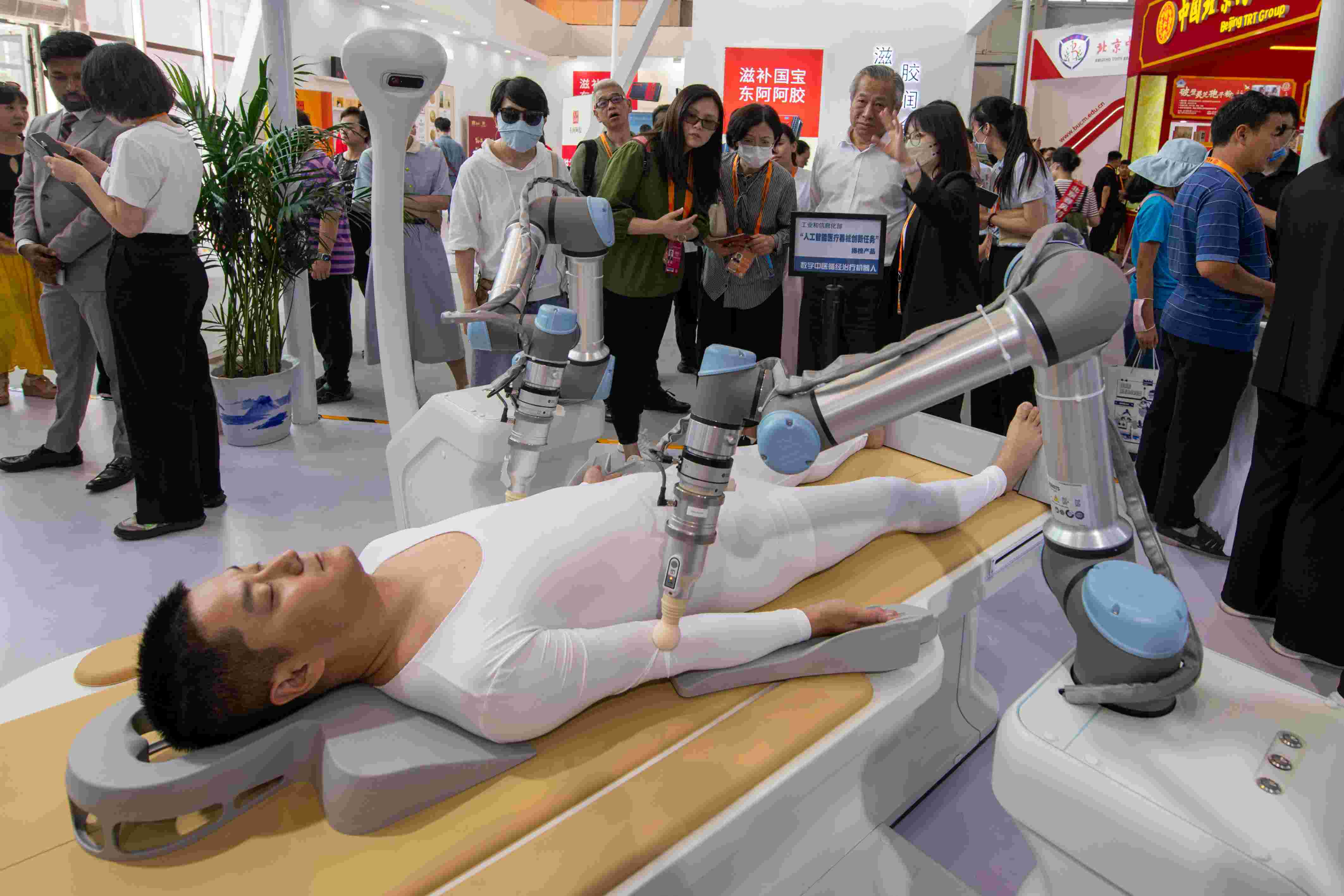 在位于首鋼園的健康衛(wèi)生服務展區(qū)，觀眾正在參觀數(shù)字中醫(yī)循經(jīng)治療機器人。人民網(wǎng)記者 翁奇羽攝