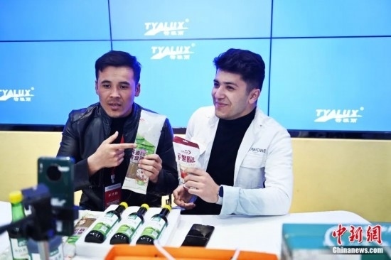 2023年3月，甘肅省慶陽市環(huán)縣電商創(chuàng)業(yè)孵化基地內(nèi)，來自蘭州文理學(xué)院的塔吉克斯坦留學(xué)生正在協(xié)助主播直播帶貨當(dāng)?shù)剞r(nóng)特產(chǎn)品。李亞龍 攝