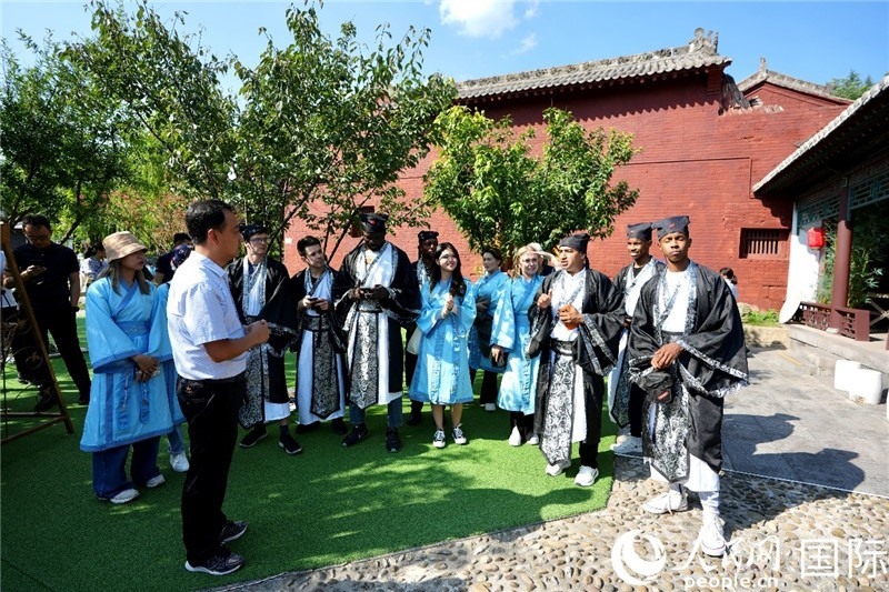 圖為選手們聽導(dǎo)游講解。人民網(wǎng) 盧鵬宇攝