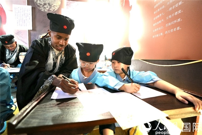 圖為選手與同學(xué)們一起寫書法。人民網(wǎng) 盧鵬宇攝