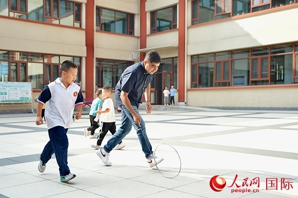 來(lái)自巴基斯坦的沙杰在滾鐵環(huán)。人民網(wǎng) 盧鵬宇攝