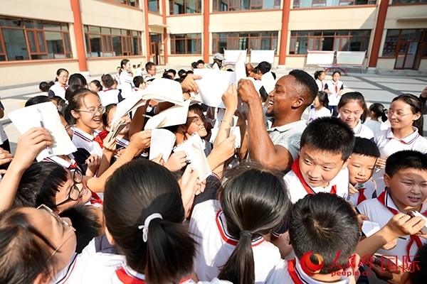 孩子們和選手互動(dòng)簽名。人民網(wǎng) 盧鵬宇攝