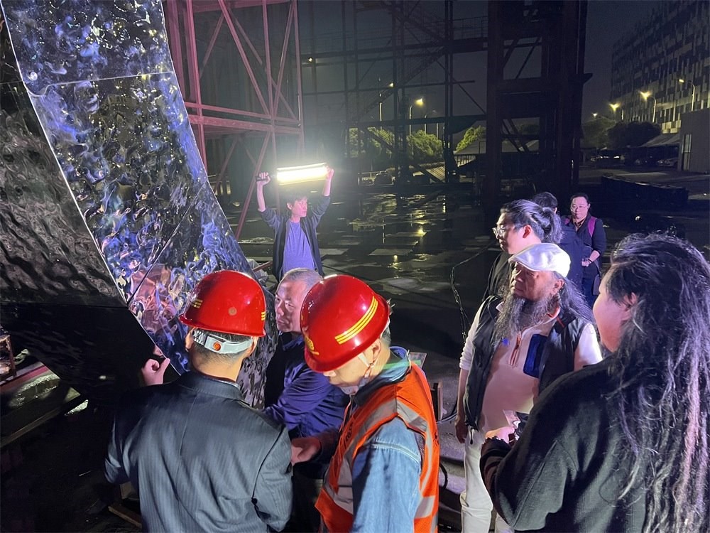 林崗（右二）和團隊查看主火炬制作進度。受訪者供圖