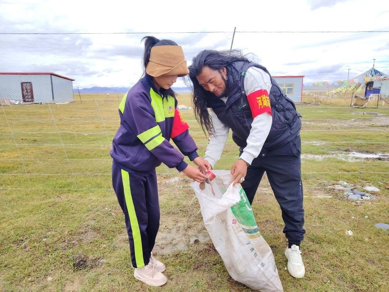 玉樹州稱多縣珍秦鎮(zhèn)河湖志愿者才培和他女兒更求拉毛在清掃垃圾。受訪者供圖
