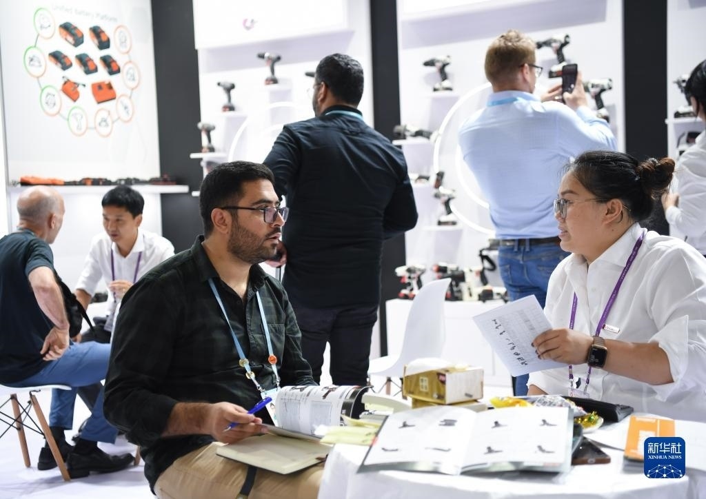 10月15日，在一家電動工具展臺，外國采購商在洽談業(yè)務。新華社記者 鄧華 攝