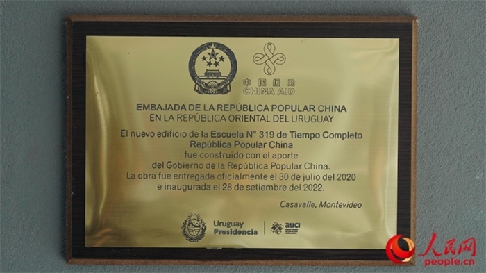 小學墻上懸掛的中國援助標識。人民網(wǎng)記者 張若涵攝