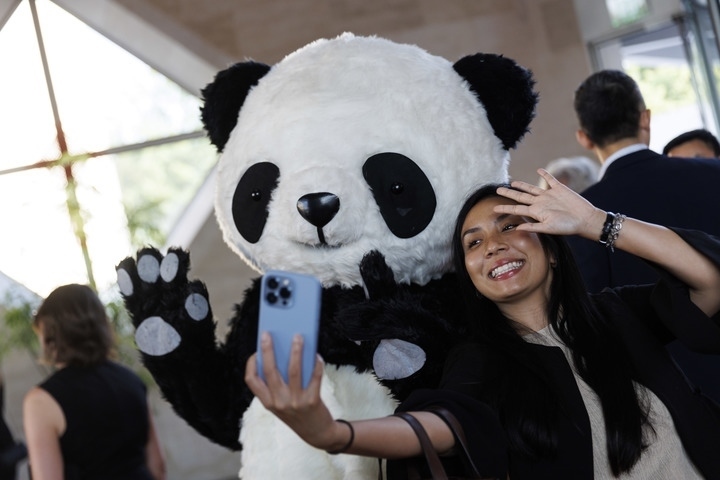 2022年8月24日，在美國華盛頓中國駐美國大使館，來賓與大熊貓玩偶合影。