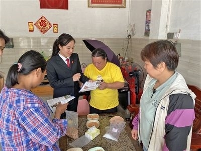  圖⑤：龍圩區(qū)法院法官到群眾家中開展法治宣傳。資料圖片