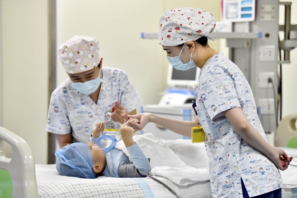 在山東省棗莊市婦幼保健院兒童ICU病房，醫(yī)護(hù)人員為完成靶向治療藥物諾西那生鈉的4歲脊髓性肌萎縮癥患兒加油鼓勁（2022年1月1日攝）。諾西那生鈉注射液是我國首個獲批治療脊髓性肌萎縮癥的進(jìn)口藥物，2019年進(jìn)入中國市場時，每針價格近70萬元。在2021年國家醫(yī)保目錄藥品談判中，以3.3萬元每針的價格進(jìn)入新版醫(yī)保藥品目錄。新華社記者 郭緒雷 攝