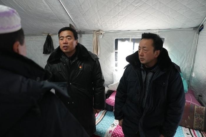 2023年12月22日，積石山縣大河家鎮(zhèn)大河村黨支部書記馬成忠（右二）在帳篷里和受災(zāi)群眾交流。新華社記者 陳斌 攝