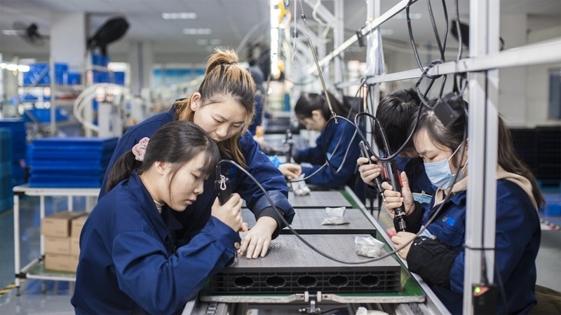 在新亞勝光電的產(chǎn)品線上，工人正進(jìn)行產(chǎn)品組建和安裝布線。受訪者供圖