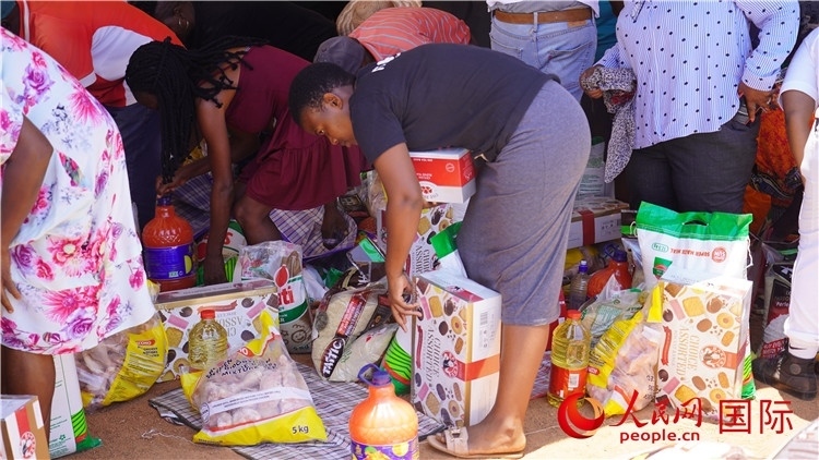 當(dāng)?shù)厣鐓^(qū)家庭領(lǐng)取物資。人民網(wǎng) 張茜攝