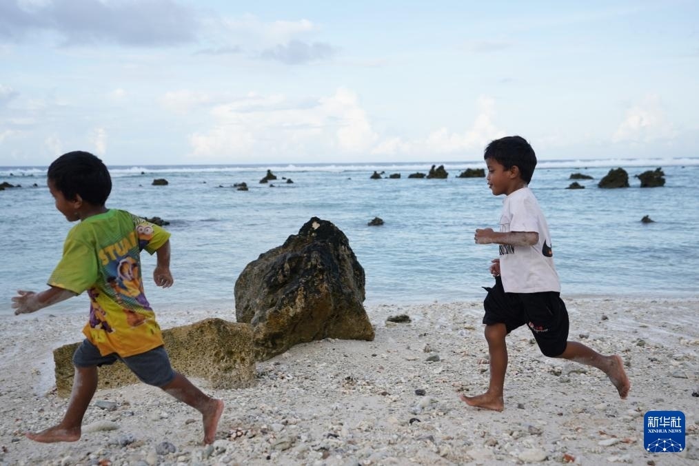 1月20日，兒童在瑙魯海邊嬉戲。新華社記者 王申 攝