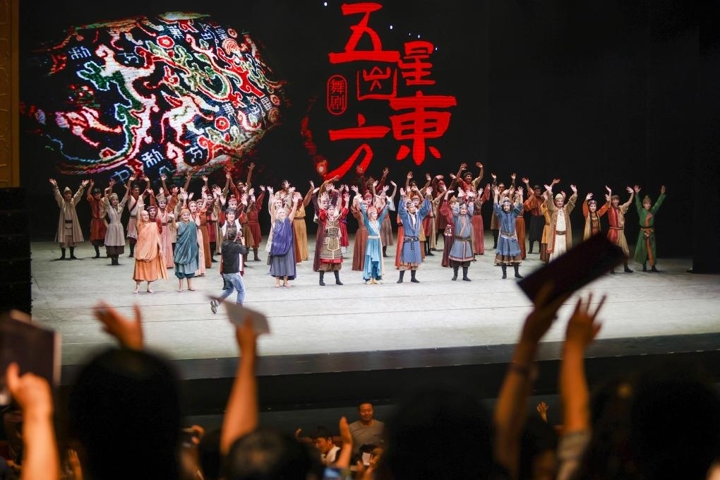 2023年7月31日，新疆和田地區(qū)新玉歌舞團(tuán)在烏魯木齊京劇院演出舞劇《五星出東方》后和觀眾互相揮手致意。這場(chǎng)演出是第六屆中國新疆國際民族舞蹈節(jié)的參演劇目之一，曾榮獲國家“文華獎(jiǎng)”等。新華社記者 郝昭 攝