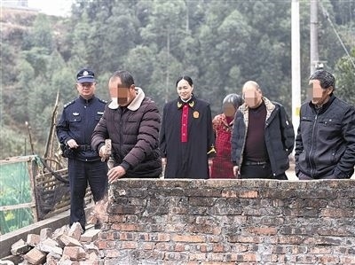  圖③：庭審結(jié)束后，在法官的見證下，陳某在院壩邊重新開鑿一條通道。