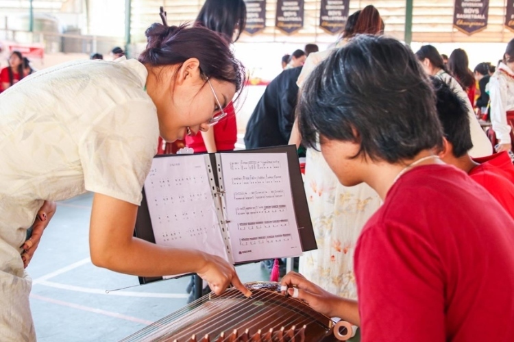 志愿者教師指導(dǎo)學(xué)生彈奏古箏?；顒?dòng)主辦方供圖