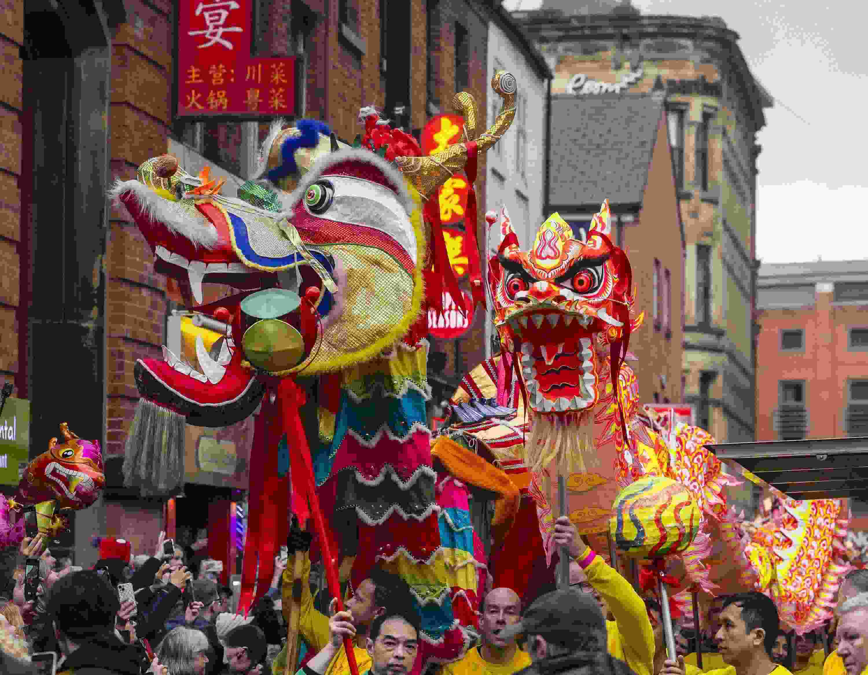 △ 當(dāng)?shù)貢r間2024年2月11日，英國曼徹斯特，表演者進入中國城，參加中國農(nóng)歷龍年春節(jié)的慶?；顒?。