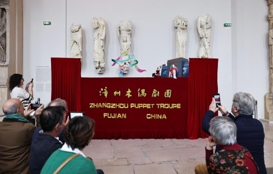 2月10日，在位于法國巴黎埃菲爾鐵塔附近的“建筑與遺產之城”博物館，觀眾欣賞漳州布袋木偶戲。新華社記者高靜攝