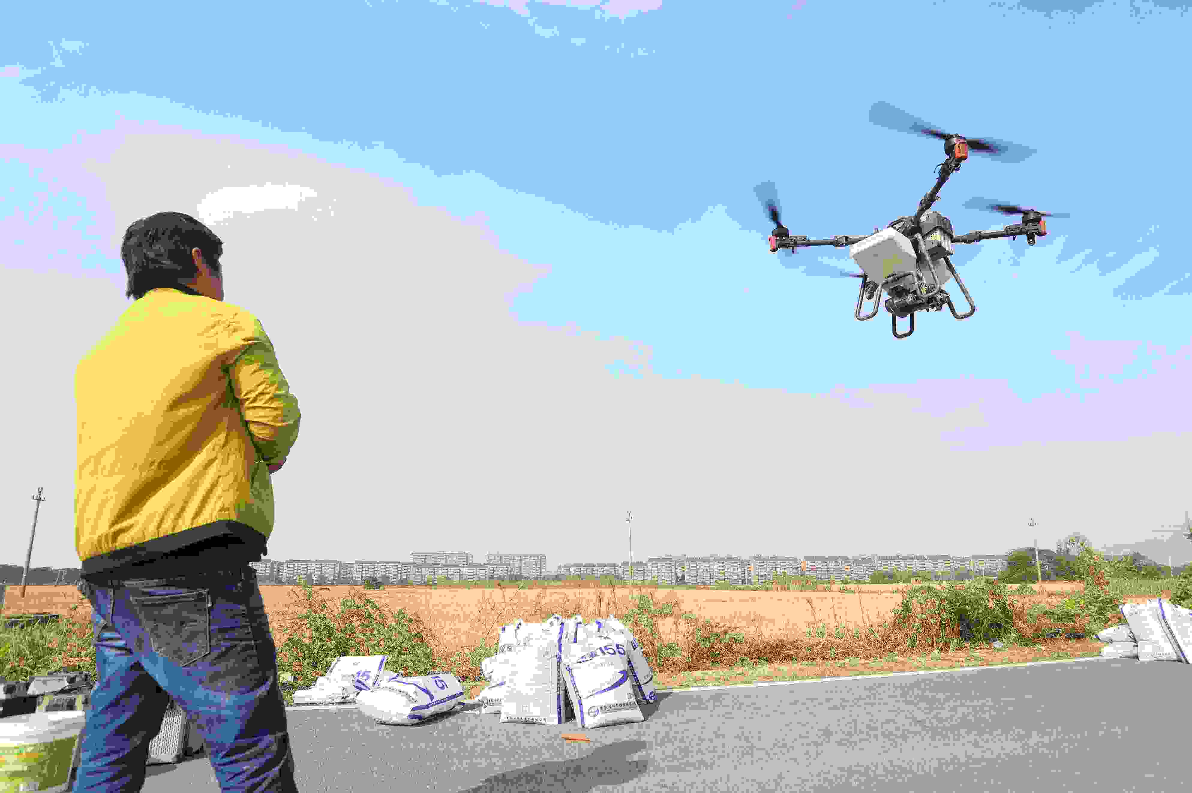 2023年11月15日，浙江嘉興，南湖區(qū)七星街道一處農(nóng)田里，農(nóng)民操縱無人機(jī)進(jìn)行冬小麥飛播。