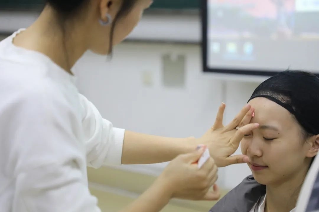 課堂上，一名學(xué)生在體驗(yàn)上戲妝。學(xué)校供圖