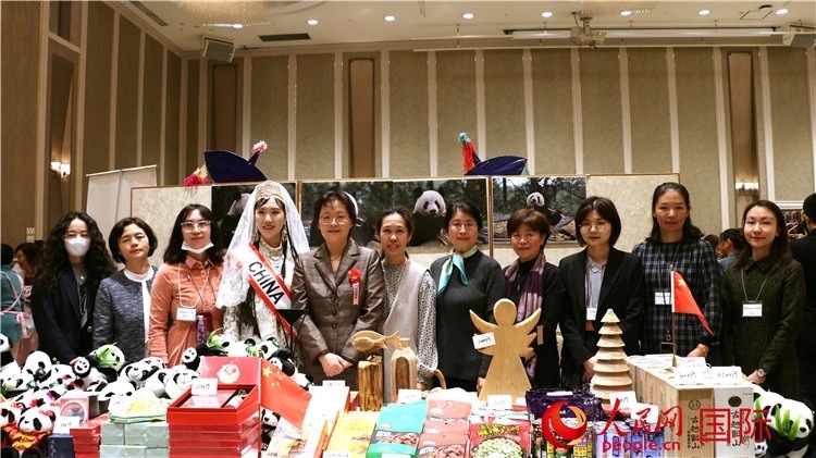 中國駐日本大使吳江浩夫人丁玥（左五）與使館人員在展位前合影留念。人民網(wǎng) 許可攝