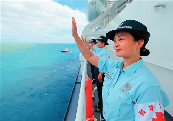 中國海軍“和平方舟”號(hào)醫(yī)院船結(jié)束訪問湯加時(shí)，任務(wù)官兵中的文職人員向歡送人群揮手告別（2023年8月4日攝）。徐巍攝/本刊