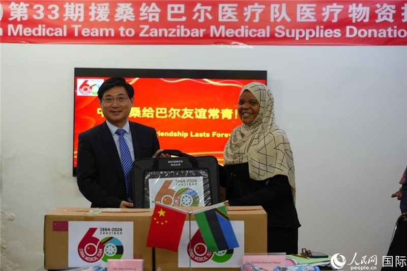 江蘇省蘇北人民醫(yī)院黨委書記束余聲捐贈物資與桑衛(wèi)生部首席秘書哈比巴。中國援桑醫(yī)療隊供圖