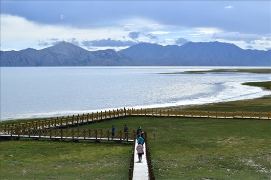 △ 游客行走在青?，敹嗫h冬格措納湖畔的木棧道上。