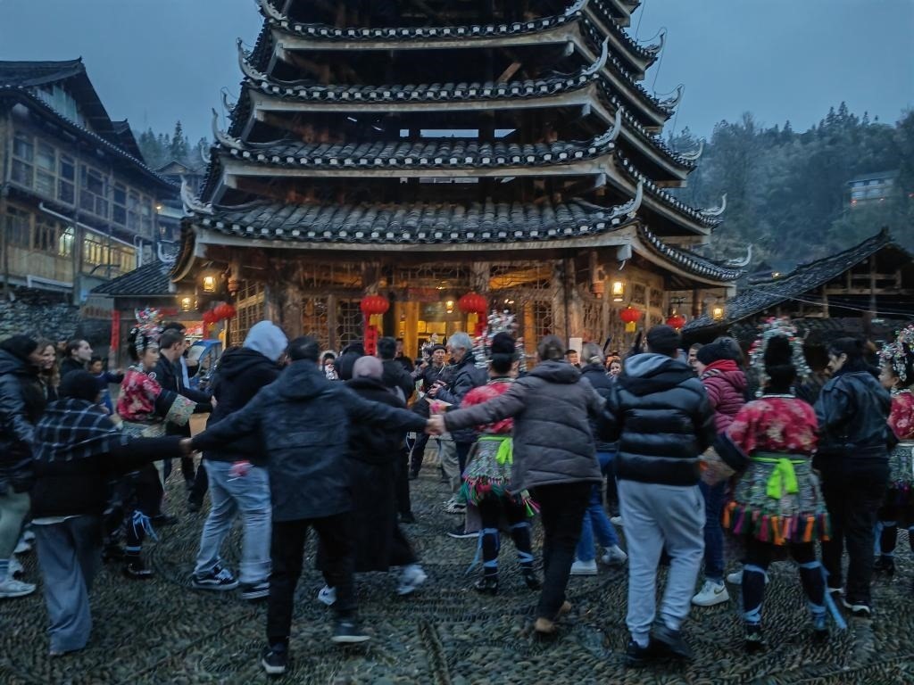 法國(guó)青年與當(dāng)?shù)卮迕駹渴痔?。新華社記者 羅羽 攝