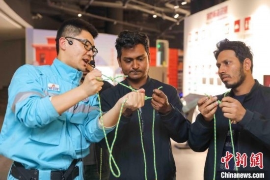 5月9日，工作人員指導(dǎo)留學(xué)生學(xué)習(xí)打繩結(jié)。張鷹 攝