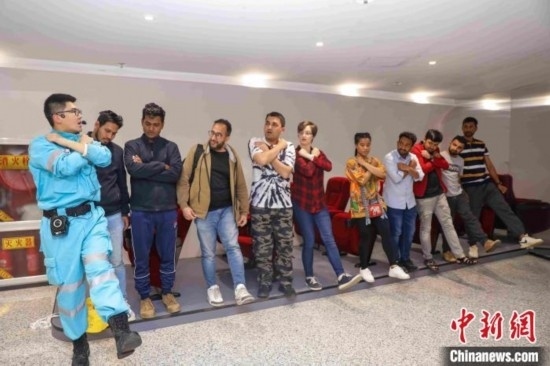 5月9日，工作人員指導(dǎo)留學(xué)生練習(xí)逃生技巧。張鷹 攝