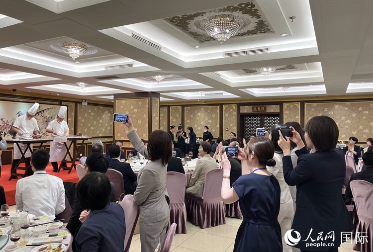 國家級非物質(zhì)文化遺產(chǎn)、全聚德片鴨工藝吸引代表團成員拍照留念。