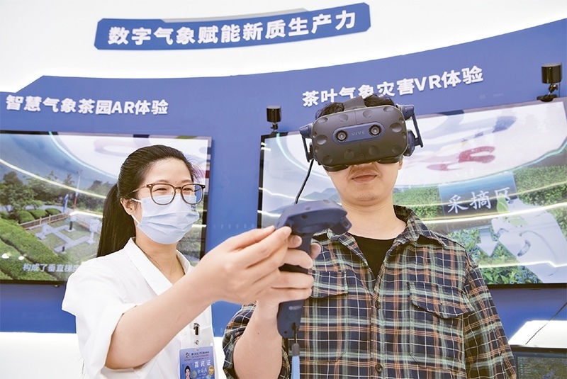 2024年5月23日，第七屆數(shù)字中國(guó)建設(shè)峰會(huì)現(xiàn)場(chǎng)體驗(yàn)區(qū)在福州海峽國(guó)際會(huì)展中心向?qū)I(yè)觀眾開放。本次現(xiàn)場(chǎng)體驗(yàn)區(qū)圍繞本屆峰會(huì)主題“釋放數(shù)據(jù)要素價(jià)值，發(fā)展新質(zhì)生產(chǎn)力”，設(shè)置“數(shù)字惠民”、“數(shù)字能力”、“數(shù)字基礎(chǔ)”、“數(shù)字生態(tài)”、“數(shù)字賦能”五大板塊。圖為一名觀眾（右）在數(shù)字氣象賦能新質(zhì)生產(chǎn)力展臺(tái)上進(jìn)行體驗(yàn)。 新華社記者 魏培全/攝