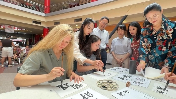 羅馬尼亞友人在活動(dòng)現(xiàn)場學(xué)寫漢字。中國駐羅馬尼亞大使館領(lǐng)僑處供圖