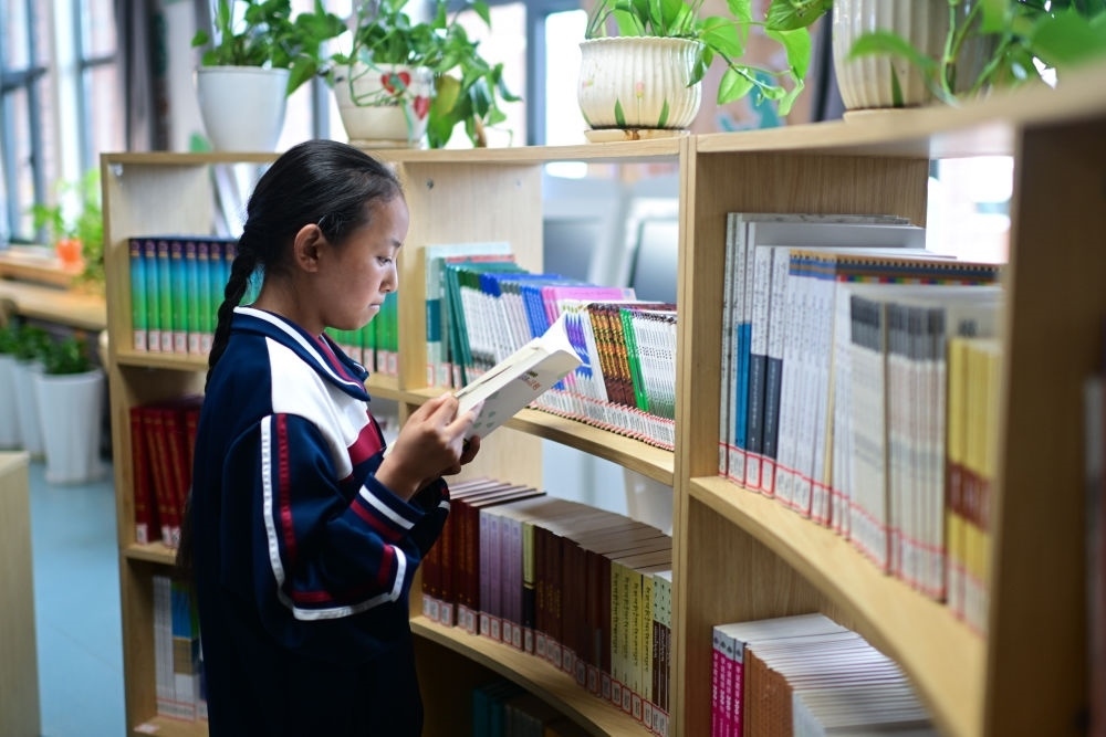 6月18日，果洛西寧民族中學(xué)學(xué)生尼東拉毛在圖書室看書。